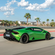 A green Huracan Tecnica speeds down the straight at a race track